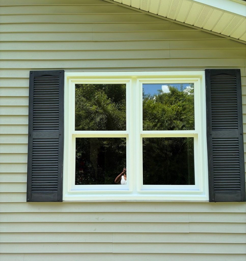 Exterior view of new double-hung bedroom window after installation.