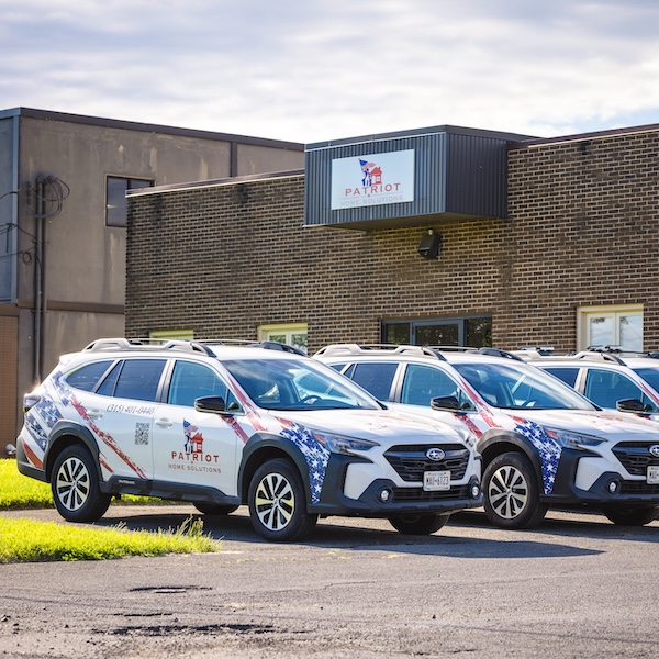 Fleet of branded Patriot Homes SUVs in front of the Patriot Homes office building