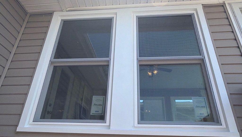 Custom white aluminum wrapping around window and door trim on a Cicero, NY home